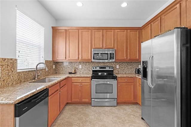 2019 Grey Falcon Cir SW, Vero Beach, FL 32962 - kitchen featuring stainless steel appliances, a sink, light stone counters, decorative backsplash, and recessed lighting