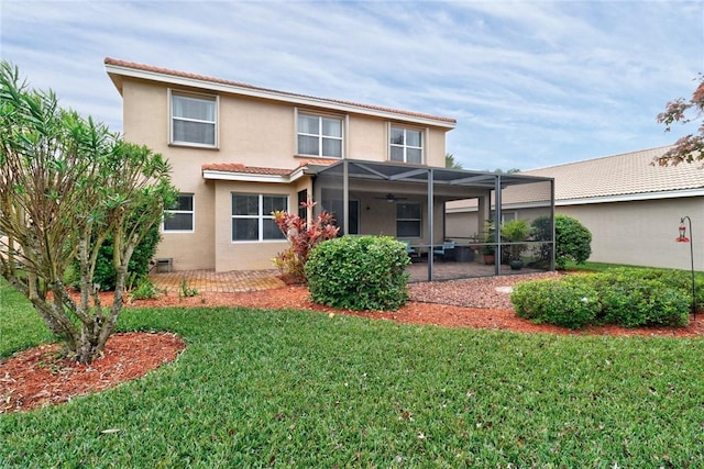 rear view of property with a lawn, a patio, stucco siding, and ceiling fan