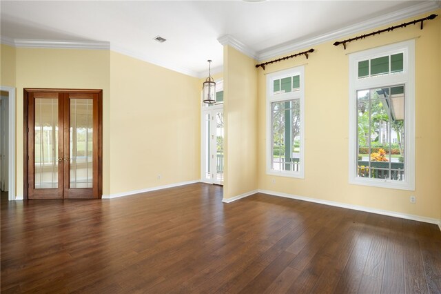 spare room featuring dark hardwood / wood-style flooring, french doors, a notable chandelier, and crown molding