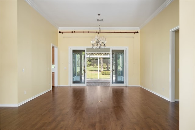 spare room with ornamental molding, dark wood-type flooring, and a chandelier