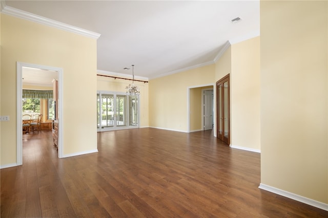 spare room with a chandelier, dark hardwood / wood-style flooring, and ornamental molding