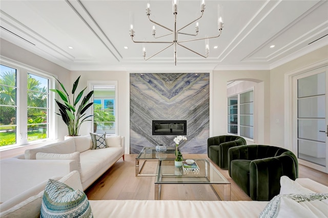 living room with ornamental molding, a fireplace, and light hardwood / wood-style flooring