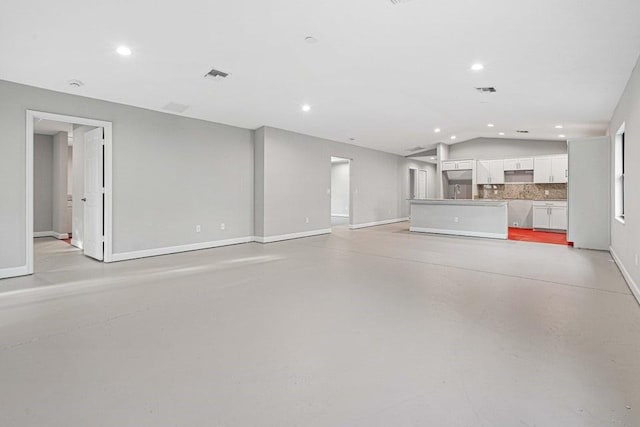 unfurnished living room with vaulted ceiling