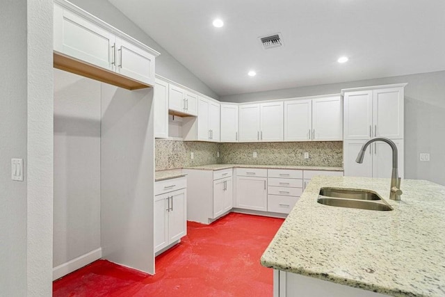 kitchen featuring sink, white cabinets, and vaulted ceiling