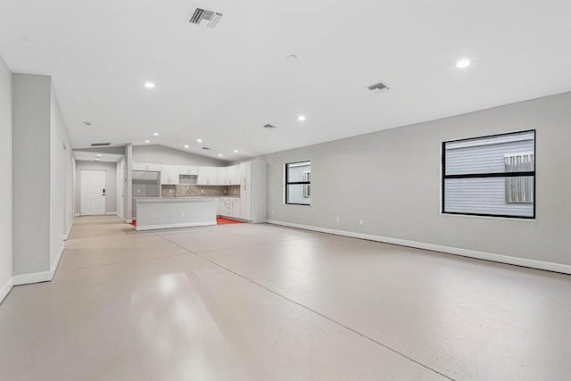 unfurnished living room featuring vaulted ceiling