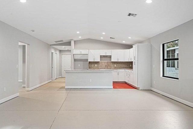 kitchen featuring white cabinets, a center island, lofted ceiling, and tasteful backsplash