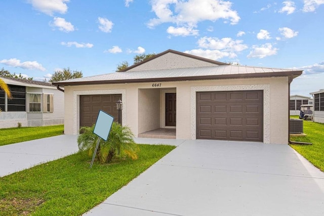 ranch-style home with a garage, central air condition unit, and a front yard