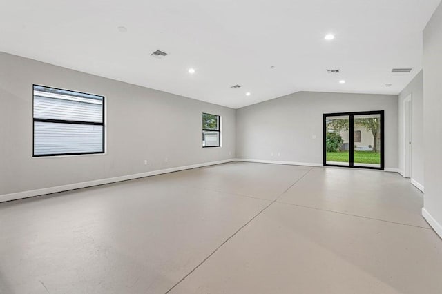 empty room with vaulted ceiling and a healthy amount of sunlight