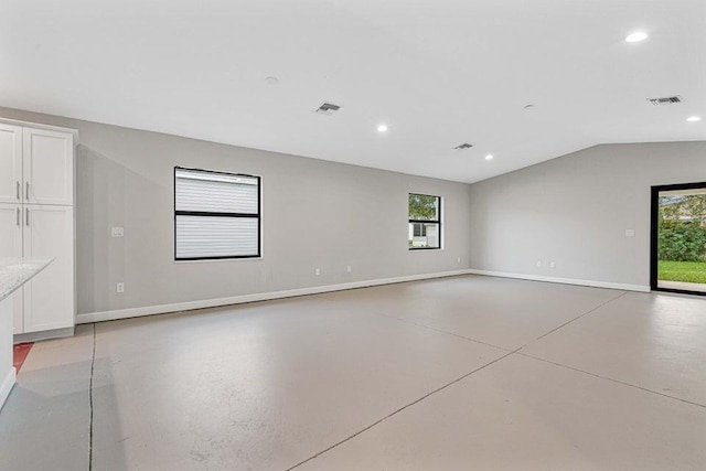 spare room with a wealth of natural light and lofted ceiling