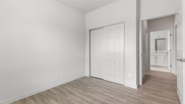 unfurnished bedroom featuring a closet and light hardwood / wood-style flooring