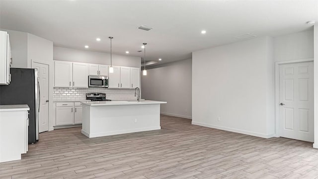 kitchen with white cabinetry, an island with sink, stainless steel appliances, and decorative light fixtures