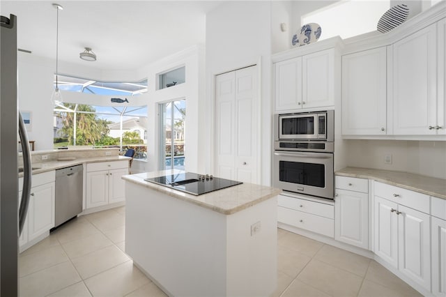 kitchen featuring white cabinets, appliances with stainless steel finishes, a kitchen island, and light tile patterned flooring