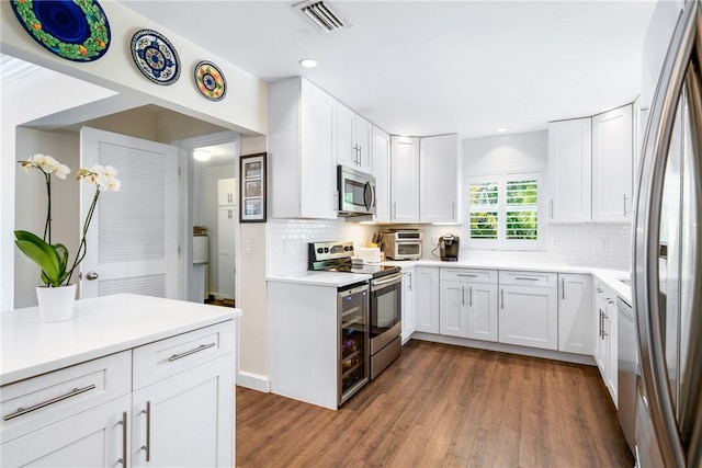 kitchen featuring stainless steel appliances, dark hardwood / wood-style floors, and white cabinets