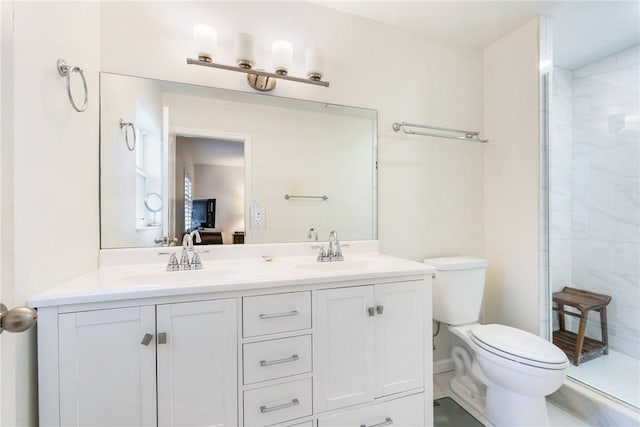 bathroom featuring vanity, toilet, and tiled shower