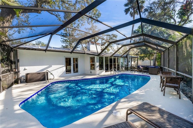 view of pool featuring a lanai, a patio area, and a hot tub