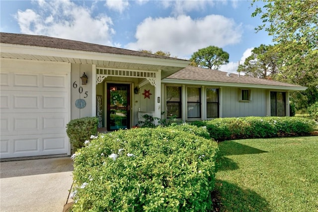 doorway to property with a lawn and a garage