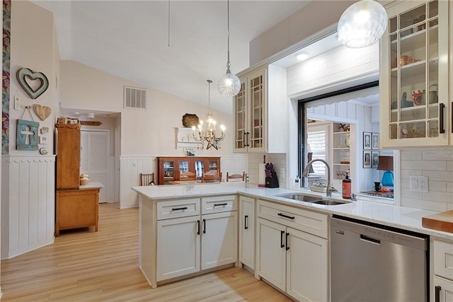 kitchen featuring sink, stainless steel dishwasher, backsplash, pendant lighting, and lofted ceiling