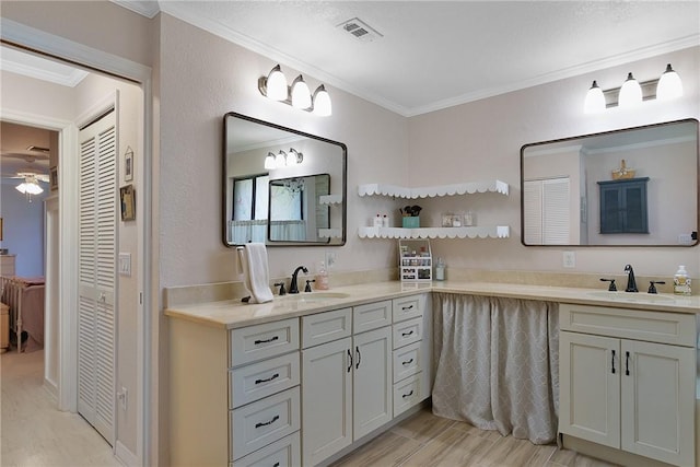 bathroom with vanity, crown molding, ceiling fan, and wood-type flooring