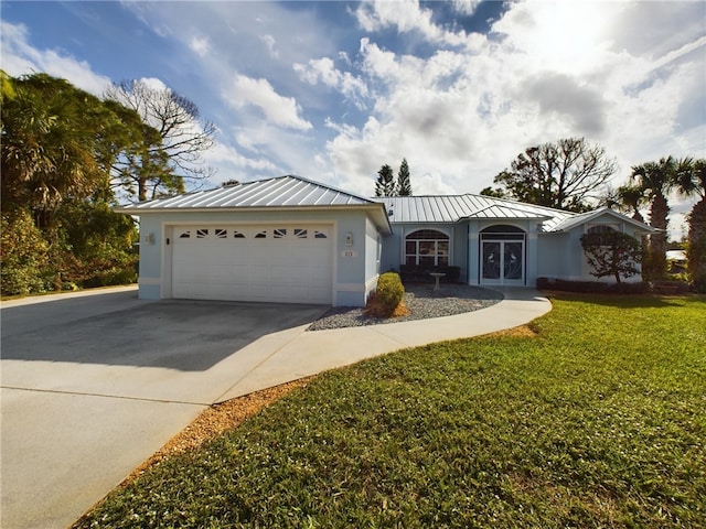 ranch-style house featuring driveway, metal roof, an attached garage, a standing seam roof, and stucco siding