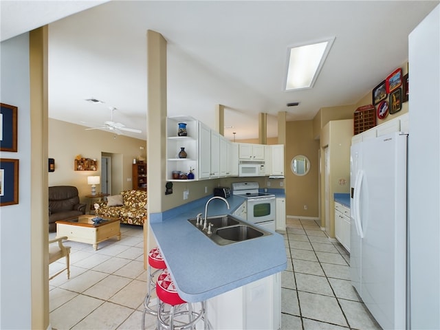 kitchen with sink, light tile patterned floors, white cabinets, and white appliances