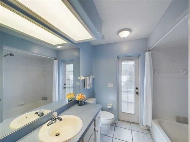 full bathroom with shower / bath combo with shower curtain, tile patterned floors, toilet, and vanity