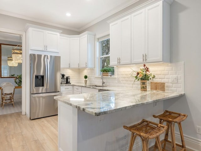 kitchen featuring white cabinets and stainless steel fridge with ice dispenser