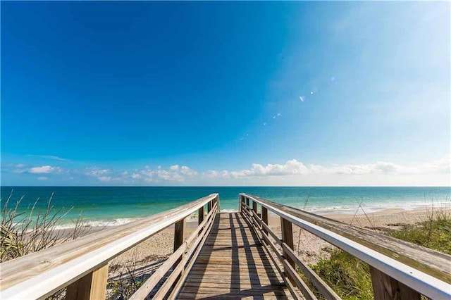 view of home's community with a water view and a beach view