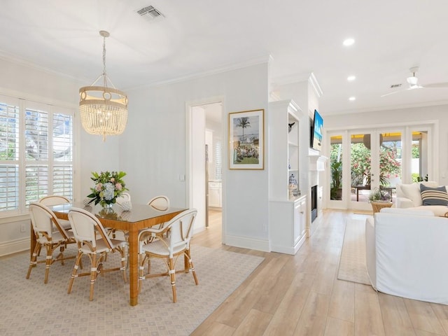 dining area featuring an inviting chandelier, crown molding, and light wood-type flooring