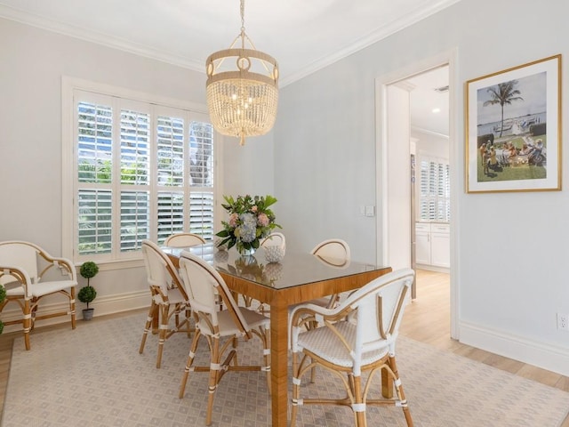 dining space with crown molding, an inviting chandelier, and light hardwood / wood-style floors