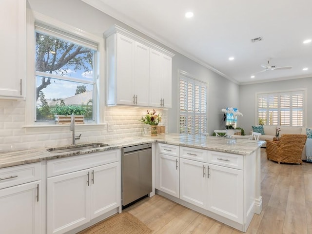 kitchen with sink, white cabinetry, stainless steel dishwasher, kitchen peninsula, and light hardwood / wood-style floors