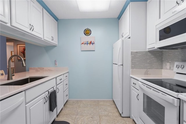 kitchen featuring white appliances, a sink, light countertops, white cabinets, and tasteful backsplash