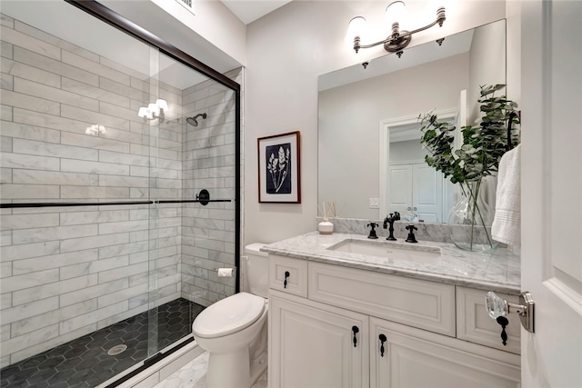 bathroom with vanity, toilet, a shower with shower door, and a notable chandelier