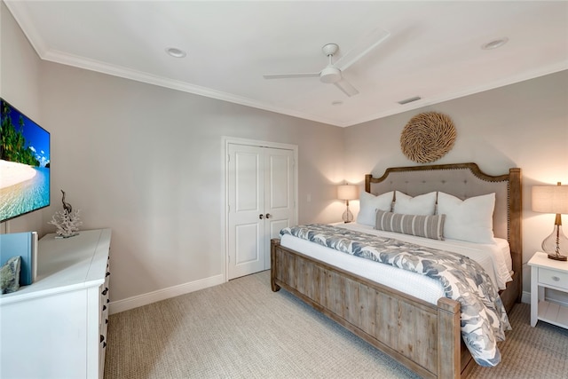 carpeted bedroom featuring crown molding, a closet, and ceiling fan