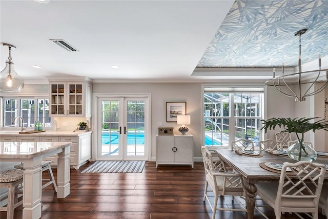 dining space featuring crown molding, sink, dark wood-type flooring, and french doors