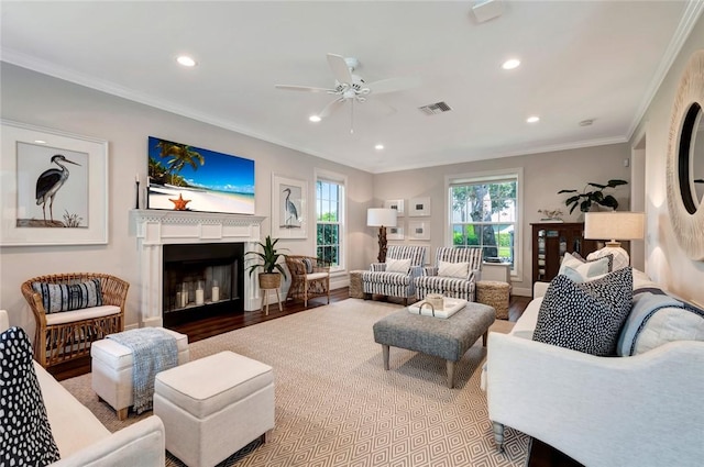 living room with ceiling fan, ornamental molding, and light hardwood / wood-style flooring