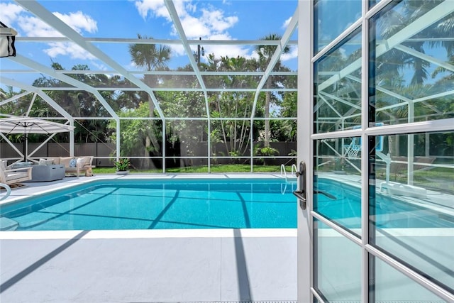 view of pool with a patio area and glass enclosure