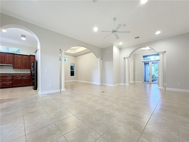 unfurnished living room featuring crown molding, decorative columns, baseboards, and a ceiling fan