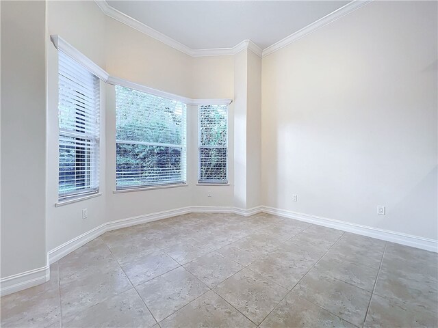 empty room featuring ornamental molding and baseboards