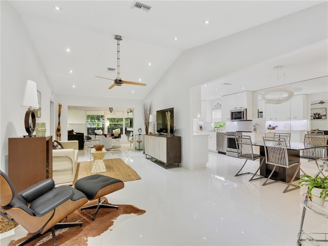 living room with high vaulted ceiling, ceiling fan, and light tile patterned flooring