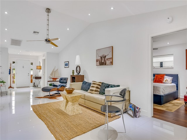 living room with ceiling fan, lofted ceiling, and light hardwood / wood-style flooring