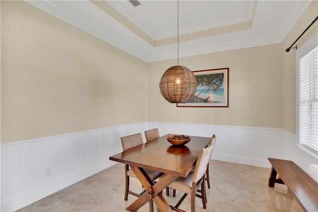 dining space featuring ornamental molding and a tray ceiling