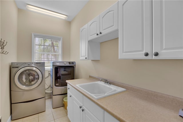 laundry room with cabinets, sink, washer and dryer, and light tile patterned floors