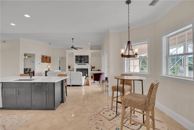 kitchen featuring crown molding, sink, decorative light fixtures, and an inviting chandelier