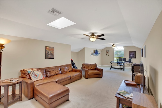 carpeted living room featuring vaulted ceiling with skylight and ceiling fan