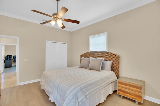 bedroom with ceiling fan, a closet, light hardwood / wood-style flooring, and ornamental molding