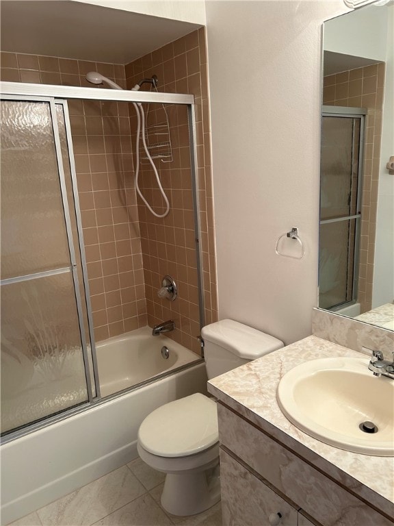 full bathroom featuring tile patterned floors, toilet, combined bath / shower with glass door, and vanity