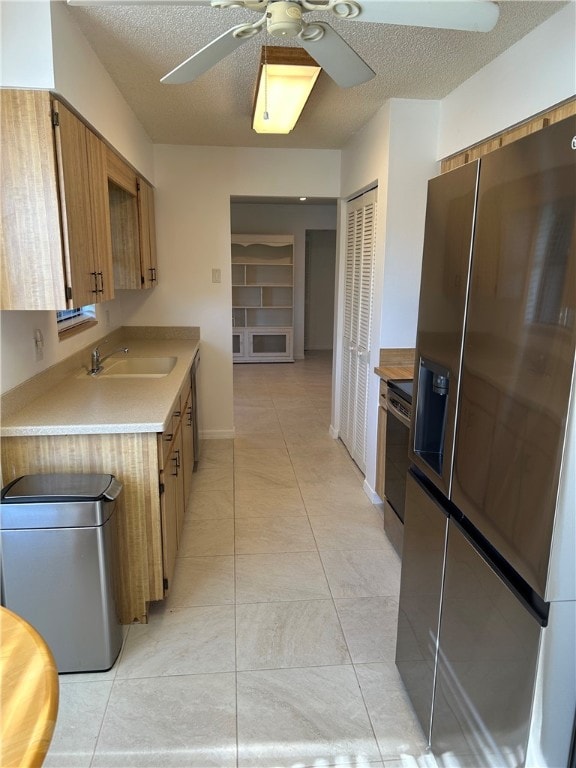 kitchen with ceiling fan, sink, a textured ceiling, and appliances with stainless steel finishes