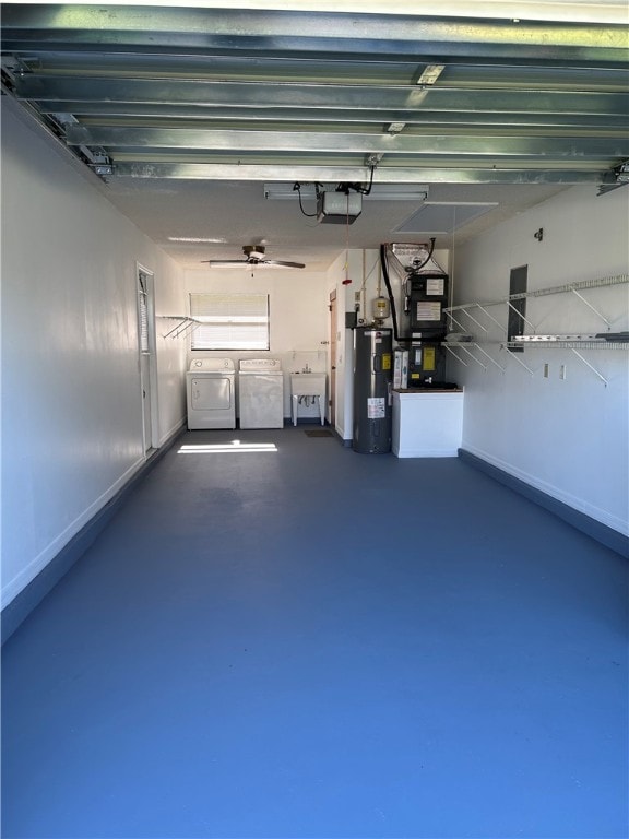 garage featuring a garage door opener, sink, independent washer and dryer, water heater, and heating unit