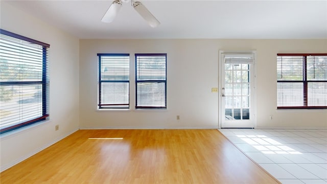 empty room with ceiling fan and light hardwood / wood-style floors