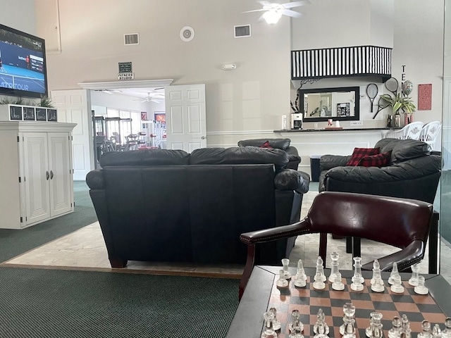 carpeted living room with a high ceiling and ceiling fan